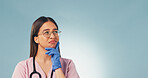 Thinking, space and nurse in studio for planning, ideas or problem solving for medical career. Gloves, woman and healthcare worker with glasses on blue background with decision, choice or question.