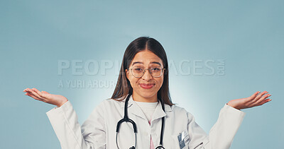 Buy stock photo Doctor, shrug and portrait of woman in studio for confused, medical opinion and treatment option. Healthcare review, mockup space and comparison with person on blue background for decision and unsure
