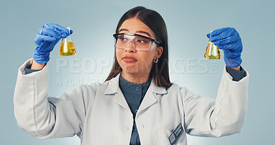 Buy stock photo Science, liquid and woman in studio with decision, options or observation for chemical reaction. Pharmaceutical, thinking and person with sample, vaccine choice or medical research on blue background