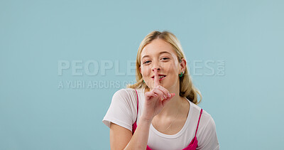 Buy stock photo Portrait, woman and secret in studio with finger to lips, mockup space and body language with smile. Happy person, confidential or private with gesture for quiet, silence or censor on blue background