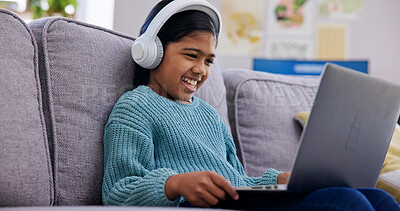 Buy stock photo Streaming, headphones or child in home with laptop, cartoon series or online game on weekend break. Happy, multimedia or girl on sofa with tech, kids entertainment or playing in digital competition.