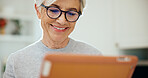 Tablet, smile and senior woman in home on website for ebook, online article and reading story. Tech, retirement and happy person at apartment for digital literature, browsing internet and info
