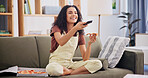 Tv remote, relax and woman with pizza on sofa in home for watching movie, show or series in living room. Happy, fast food and person eating takeaway dinner with streaming film on weekend in apartment