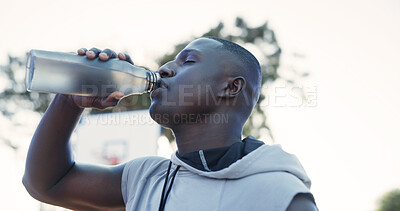 Buy stock photo Fitness, black man and drinking water for health outdoor, wellness or recovery on break. Bottle, male person and athlete with electrolytes for cool down, sports rest and hydration on basketball court