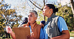 Clipboard, instructions and pointing with volunteer people in park together for charity or relief work. Conversation, inventory and paperwork with community team outdoor for discussion or planning