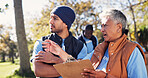 Clipboard, pointing and talking with volunteer people in park together for charity or relief work. Conversation, instructions and paperwork with community team outdoor for discussion or planning