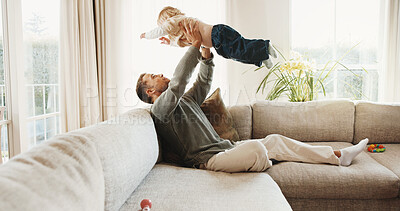 Buy stock photo Father, play and lift baby on sofa for support, love and bonding together with child at home. Couch, flying and parent with kid for care, plane game and family connection with toddler for trust