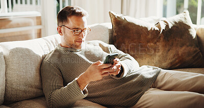 Buy stock photo Phone, smile and man on sofa in home with texting, chatting or social media advice on mobile app. Tech, relax and person on cellphone for reading online blog for tips in living room at apartment