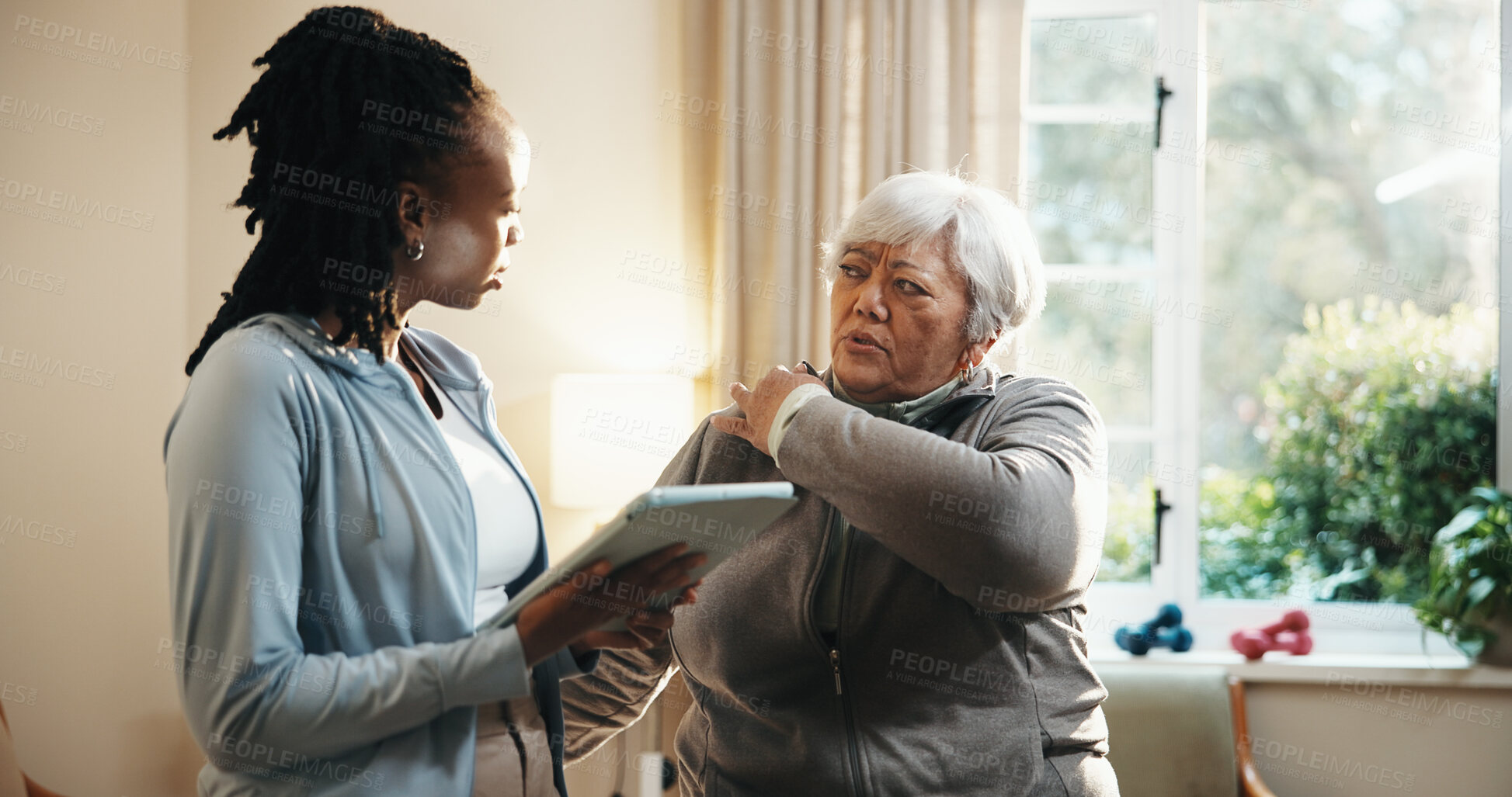 Buy stock photo Old woman, shoulder pain and physiotherapist with tablet in home for consulting or rehabilitation. App, feedback and senior patient with chiropractor in apartment for concern, recovery or review