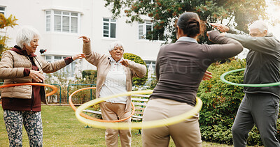 Buy stock photo Woman, physiotherapist and hoop with senior group in garden for outdoor exercise together. Female person, fitness or instructor training with elderly people or ring for workout in retirement park