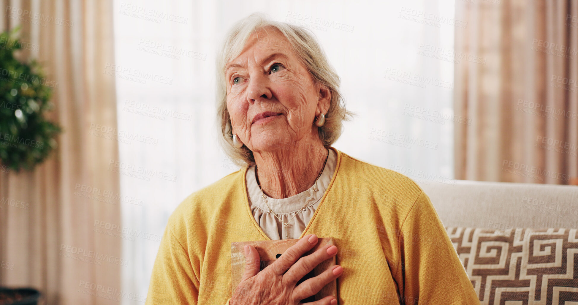 Buy stock photo Thinking, old woman and memory at house with picture frame, remembrance and nostalgia reminder. Smile, reflection and senior person in lounge with photo album, reminiscing moment and mourning loss