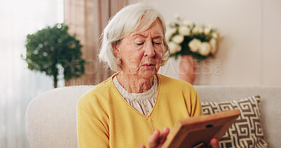 Buy stock photo Sad, old woman and memory at house with picture frame, remembrance and nostalgia for loneliness. Grief, sentimental and senior person in lounge with photo album, reminiscing moment and mourning loss
