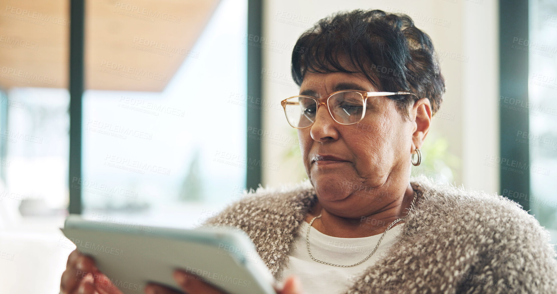 Buy stock photo Senior, woman and reading in house with tablet, glasses and search website for ebook on weekend break. Pensioner, person and internet in home with tech, online news article and relax for retirement.