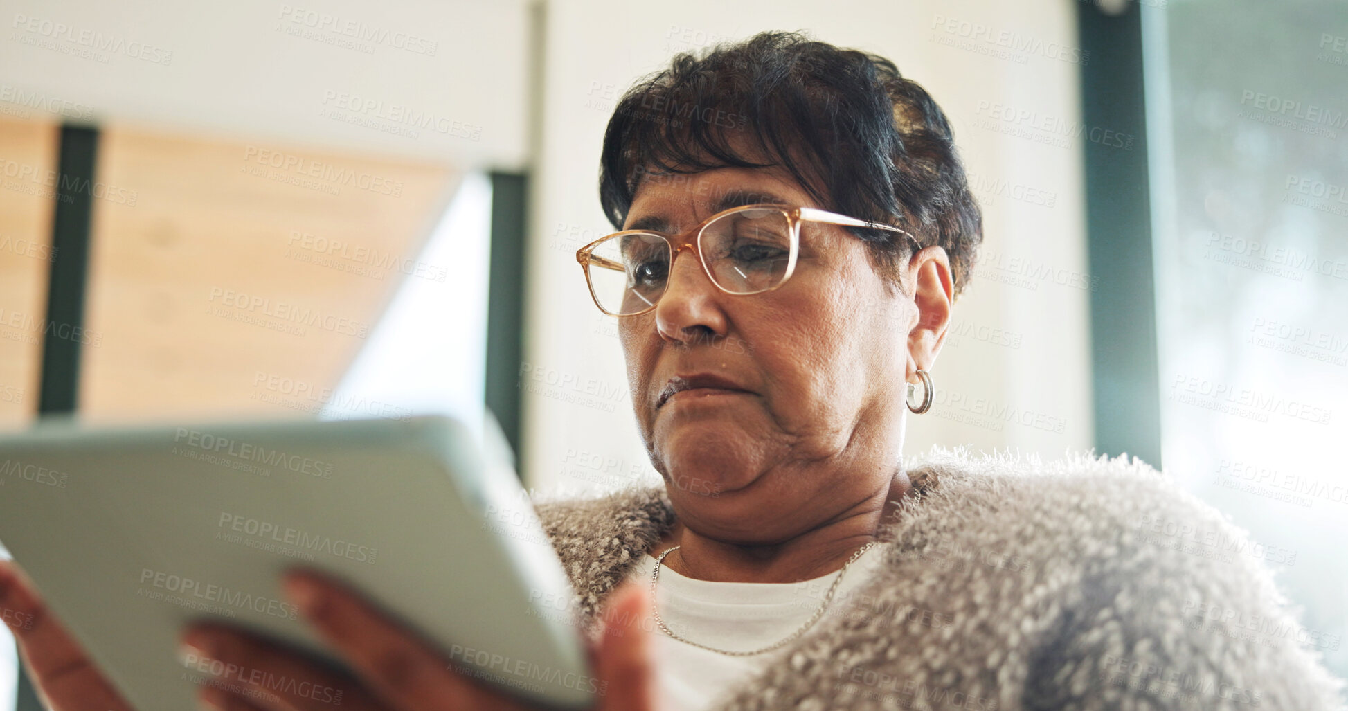 Buy stock photo Senior, woman and reading in home with tablet, glasses and search website for ebook on weekend break. Pensioner, person and internet in house with tech, online news article and relax for retirement.