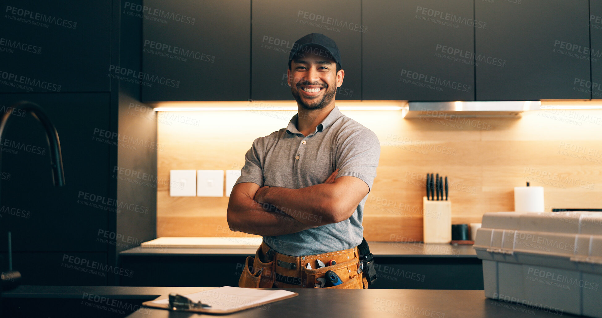 Buy stock photo Handyman, clipboard and portrait of man in kitchen for plumbing service, maintenance and repair. Paperwork, home and person with utility belt, pride and crossed arms for project, renovation or fixing