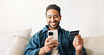 Credit card, phone and happy man on sofa for online shopping, purchase and internet banking. Smile, home and person on mobile app for debit info for ecommerce, subscription and discount on website