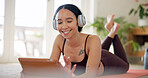 Home, woman and tablet with headphones for fitness app, virtual exercise lesson and listen to music. Happy person, training or workout rest on floor with audio tech, wellness or search video tutorial