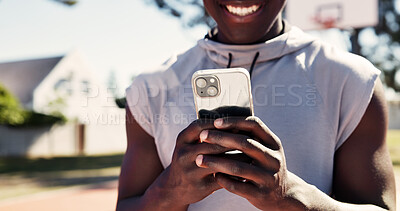 Buy stock photo Exercise, app and phone with hands of man on basketball court for message, tracker and social media. Summer, sport and training with person in park for health, tech and workout planning outdoor