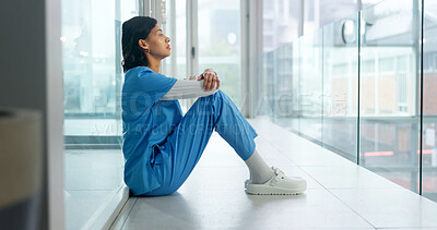 Buy stock photo Thinking, stress and nurse in hospital with medical burnout, fatigue or worry for malpractice. Reflection, tired woman or healthcare worker on floor with ethical concern, shift pressure or fail