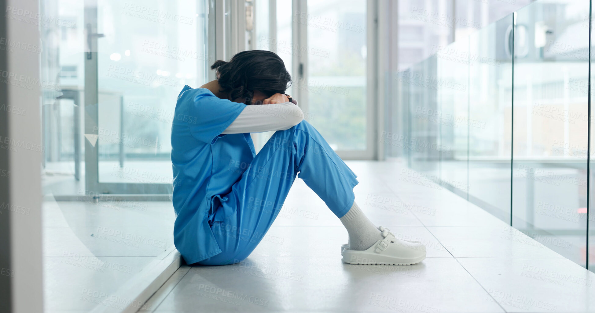 Buy stock photo Woman, stress and tired nurse in hospital with medical burnout, surgery mistake or overwhelmed. Fatigue, healthcare worker or person with depression on floor for patient loss, shift pressure or fail