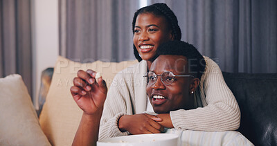 Buy stock photo Couple, laugh and watching tv with popcorn in lounge, entertainment or bonding with partner in home. Happy, black people and eating snack in living room, embrace and streaming funny movie in house