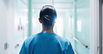 Back, nurse and walking in clinic for healthcare, punctual female person and wellness service. Woman, hospital hallway and arrival of professional clinician, medical duty and shift at corridor