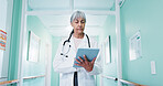 Doctor, woman and tablet for medical report, review schedule or reading case study in hallway. Tech, mature person and healthcare worker in hospital for electronic health records, history and admin