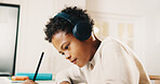 Child, headphones and writing in house with homework, learning knowledge and listen to radio music. Boy, study and taking notes in home with school task, education and audio tech for streaming song.