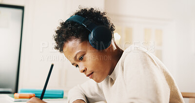 Buy stock photo Child, headphones and writing in house with homework, learning knowledge and listen to radio music. Boy, study and taking notes in home with school task, education and audio tech for streaming song.
