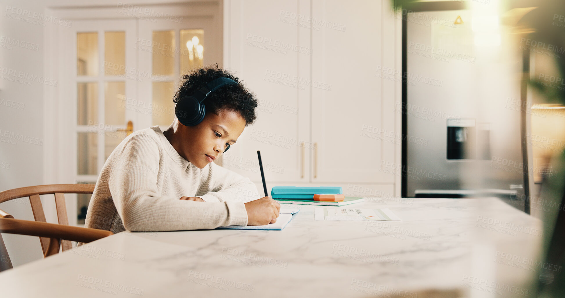 Buy stock photo Kid, headphones and writing in house with homework, learning knowledge and listen to music playlist. Boy, child and taking notes in home with school task, education and audio tech for streaming song.