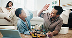 Child, dad and high five with toy car for engineering, online tutorial or remote control vehicle in home. Family, son and father with tablet for guide with robotics, junior mechanic or development