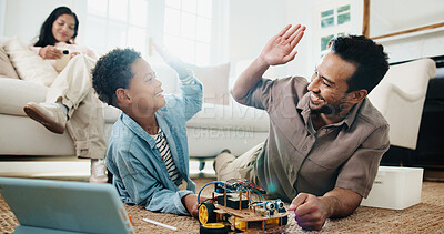 Buy stock photo Child, dad and high five with toy car for engineering, online tutorial or remote control vehicle in home. Family, son and father with tablet for guide with robotics, junior mechanic or development