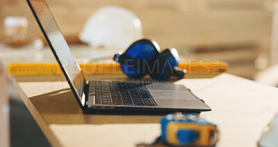 Buy stock photo Carpentry, laptop and earmuffs on desk in workshop for hearing protection or safety equipment. Woodwork, technology and computer for order of timber project or furniture manufacturing in factory.