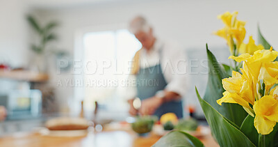 Buy stock photo Flowers, man and cooking in kitchen for diet, health and nutrition in retirement at home. Senior person, meal prep and floral bouquet in bloom with growth, decoration or canna lilies for natural food