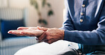 Hands, massage and old woman in retirement home with wrist pain, arthritis symptoms and osteoporosis. Senior person, joint inflammation and sprain in house with injury, medical condition and gout.