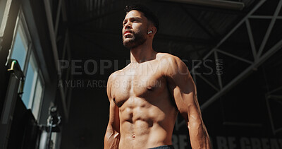 Buy stock photo Fitness, gym and bodybuilder man with music and thinking of training, muscle growth and self care. Earphones, workout playlist and person or health club membership for exercise, strong and wellness