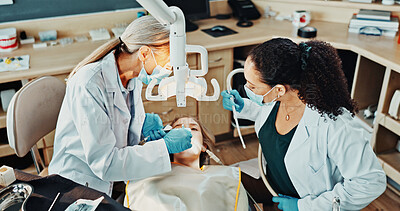 Buy stock photo Dentist, team and patient in clinic for procedure, dental suction and drill for cleaning tooth decay. Orthodontics, women and help for oral hygiene, tools assistant and medical health with ppe