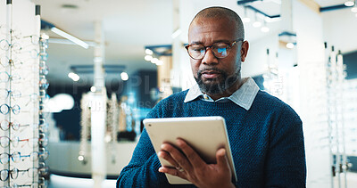 Buy stock photo Glasses, man and tablet in store for optometry, order custom lenses or access EHR system. Optical assistant, eyewear or mature black person with tech for stock check, online inventory or product info