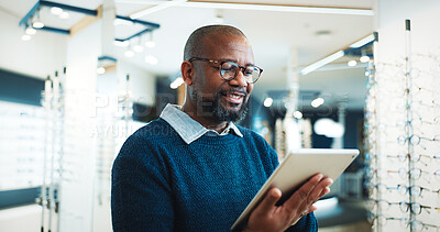 Buy stock photo Optometry, typing and man on tablet for store inventory, stock and checklist for frames. Shop, mature and African person on digital tech with prescription lens, spectacles and glasses for vision