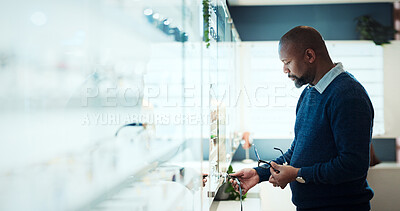 Buy stock photo Frame, search and optometry with black man in store for prescription, eye care or spectacle option. Glasses, ophthalmology and lens choice with person in clinic for vision health and optical wellness