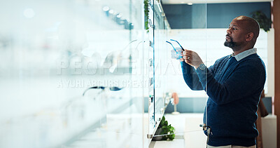 Buy stock photo Glasses, search and optometry with black man in store for prescription, eye care or spectacle option. Space, ophthalmology and lens choice with person in clinic for vision health and optical wellness