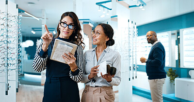 Buy stock photo Optometry, tablet and pointing with women in store for  consulting, glasses advice or vision. Lens fitting, online prescription and eye care with client and optometrist in clinic for ophthalmology