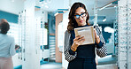 Glasses, woman and tablet in shop for optometry, order custom lenses or access EHR system. Optical assistant, eyewear and mature employee with tech for stock check, online inventory or product info
