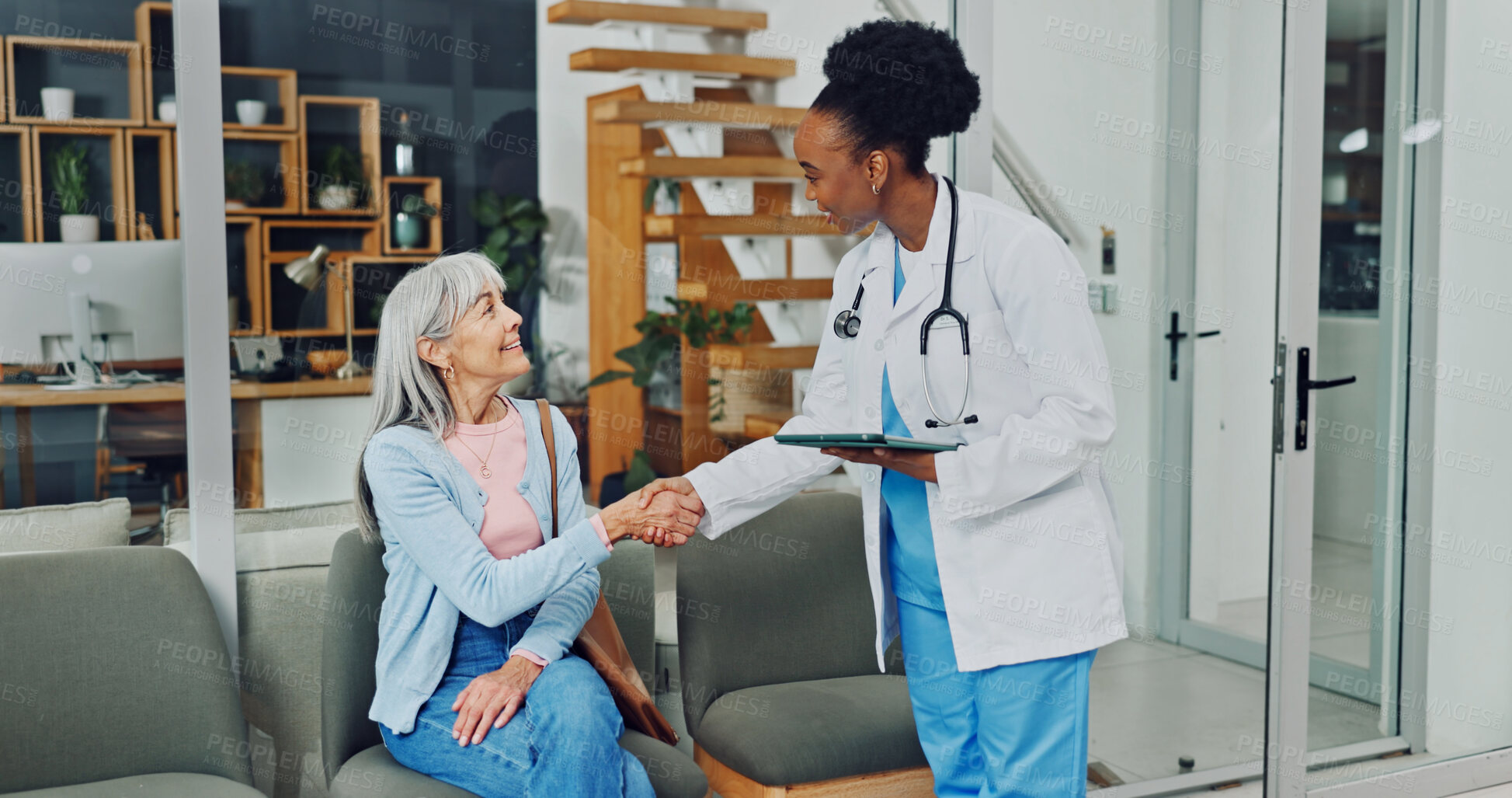 Buy stock photo Doctor, handshake and old woman in office with greeting, tablet and medical appointment for wellness. Happy, senior person and healthcare worker shaking hands with tech, discussion and consultation.