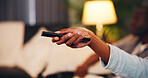 Person, hands and watching tv with remote in home for online entertainment or subscription. User, relax and changing channel with controller signal on sofa for weekend connection or holiday in house
