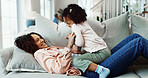 Mother, laugh and tickle child in home with humor, family time or bonding together for weekend break. Happy, woman relax and play in living room with daughter, funny game and connection for wellness.