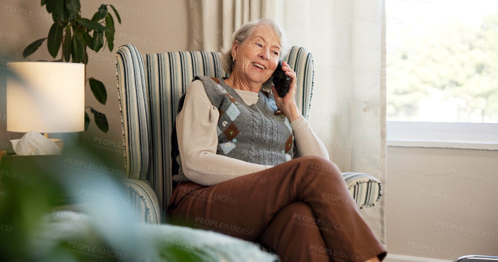 Buy stock photo Phone call, smile and elderly woman on chair in living room for discussion, gossip or communication. Technology, relax and senior person in retirement home with tech for conversation and break