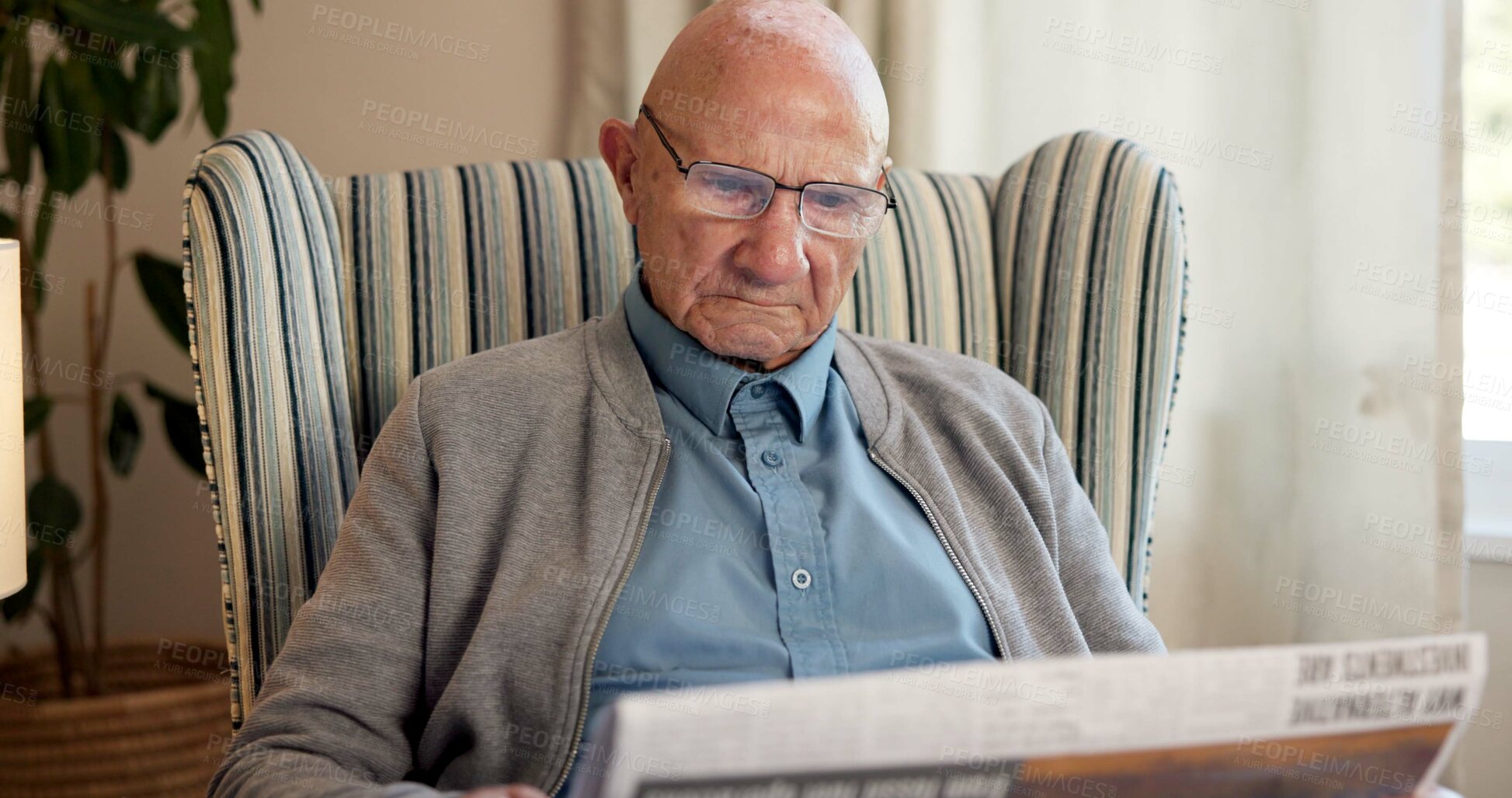 Buy stock photo Reading, newspaper and relax with elderly man in living room of home for break or information. Article, glasses and retirement with old person on chair in apartment for media publication or report