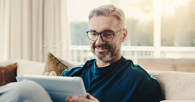 Buy stock photo Smile, man and reading at house with tablet, social media and browsing online for latest movies. Happy, mature person and relax in lounge with tech, internet search and streaming for film watchlist
