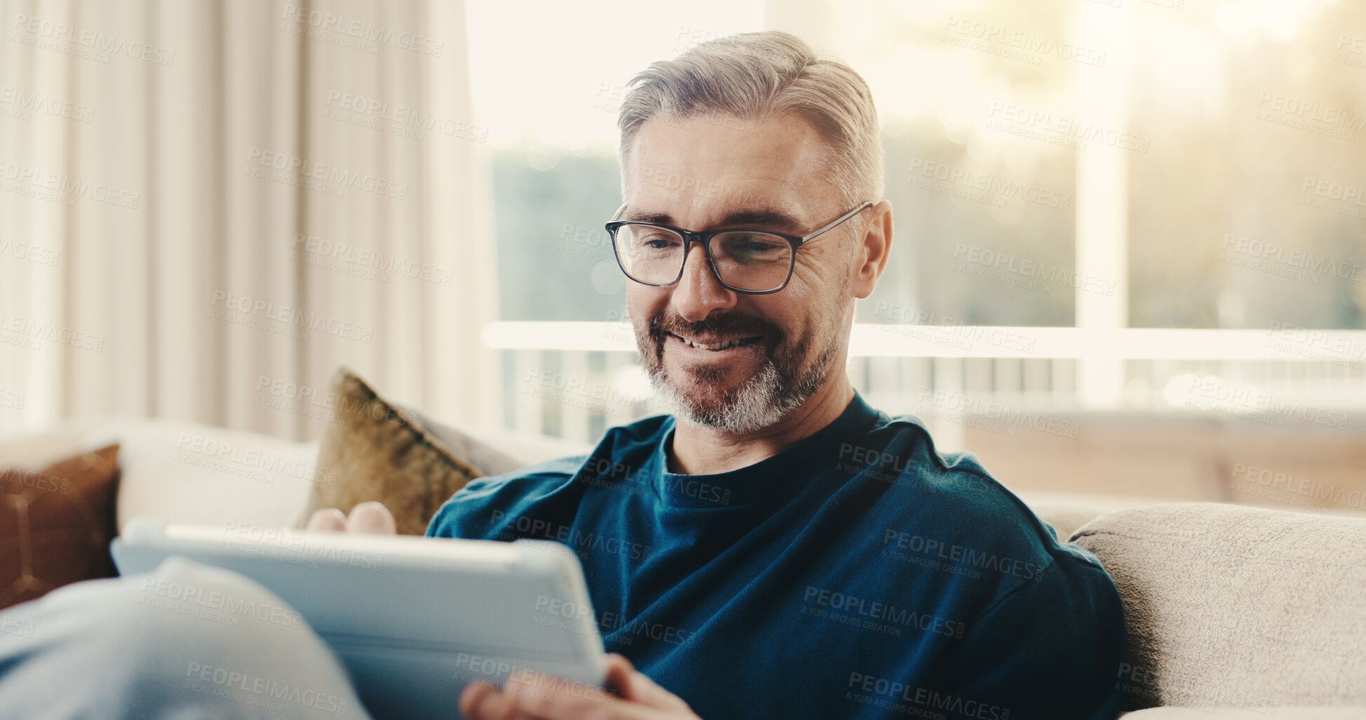 Buy stock photo Smile, man and reading at house with tablet, social media and browsing online for latest movies. Happy, mature person and relax in lounge with tech, internet search and streaming for film watchlist
